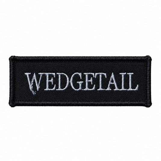 Black rectangular patch with embroidered silver ’wedgetail’ text